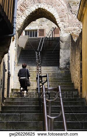 Stock Photography - Rear view of a woman moving up on staircase, Escalier de la Grande Poterne, Le Mans, Sarthe, France. Fotosearch