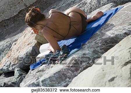 Rear view of a woman reclining on a rock and reading a book, RioMaggiore, Cinque Terre, Italian Riviera, Cinque Terre National Park, Vernazza, La Spezia, Liguria, Italy View Large Photo Image Stock Image - Rear view of a woman reclining on a rock and reading a book, RioMaggiore, Cinque Terre, Italian Riviera, Cinque Terre National Park, Vernazza, La Spezia, Liguria, Italy. Fotosearch
