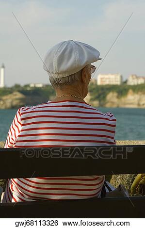 Rear view of a woman sitting on a bench, Phare De Biarritz, Baie De Biarritz, Biarritz, France View Large Photo Image Stock Photograph - Rear view of a woman sitting on a bench, Phare De Biarritz, Baie De Biarritz, Biarritz, France. Fotosearch