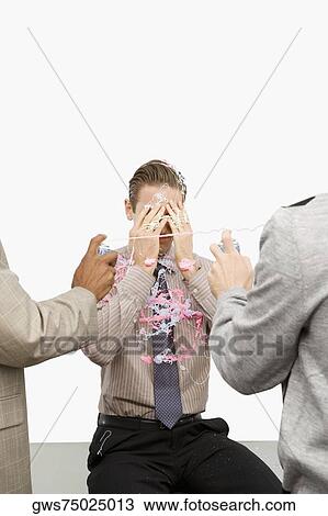 Rear view of two businessmen spraying a businessman with silly string View Large Photo Image Stock Image - Rear view of two businessmen spraying a businessman with silly string. Fotosearch