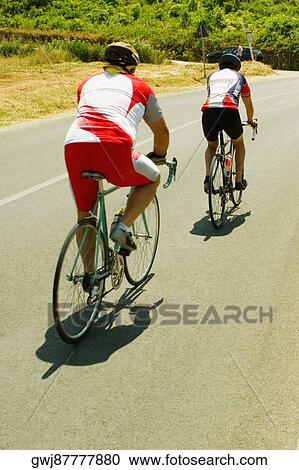 Rear view of two cyclists on the road, Siena Province, Tuscany, Italy View Large Photo Image Stock Image - Rear view of two cyclists on the road, Siena Province, Tuscany, Italy. Fotosearch