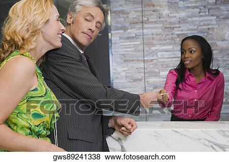 Receptionist giving cardkey to a customer View Large Photo Image Stock Photo - Receptionist giving cardkey to a customer. Fotosearch