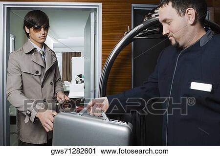 Room service man handing over a briefcase to a businessman View Large Photo Image Stock Image - Room service man handing over a briefcase to a businessman. Fotosearch