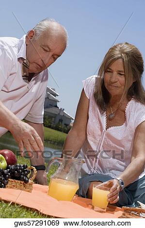 Senior couple enjoying juice at picnic View Large Photo Image Stock Photo - Senior couple enjoying juice at picnic. Fotosearch