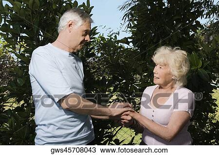 Senior couple holding each other hands in a garden View Large Photo Image Stock Image - Senior couple holding each other hands in a garden. Fotosearch