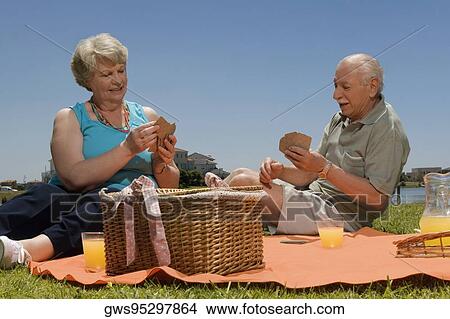 Senior couple playing cards at picnic View Large Photo Image Picture - Senior couple playing cards at picnic. Fotosearch