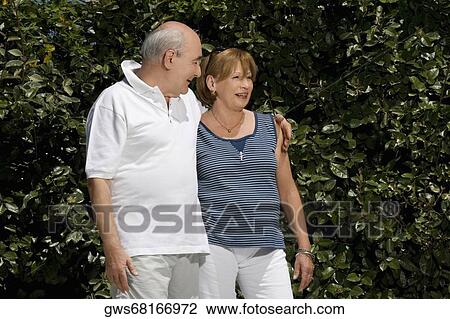 Senior couple smiling in a park View Large Photo Image Stock Image - Senior couple smiling in a park. Fotosearch