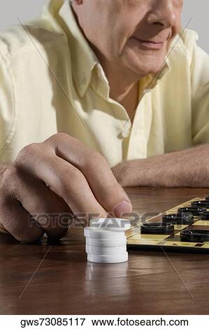 Senior man playing checkers View Large Photo Image Stock Photo - Senior man playing checkers. Fotosearch