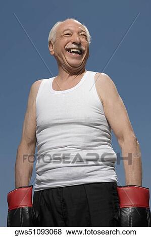 Senior man wearing boxing gloves and smiling View Large Photo Image Stock Photo - Senior man wearing boxing gloves and smiling. Fotosearch