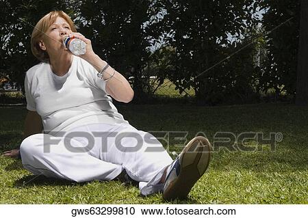 Senior woman drinking water in a garden View Large Photo Image Stock Image - Senior woman drinking water in a garden. Fotosearch