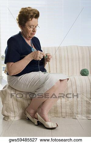 Senior woman sitting on a couch and knitting View Large Photo Image Stock Photo - Senior woman sitting on a couch and knitting. Fotosearch