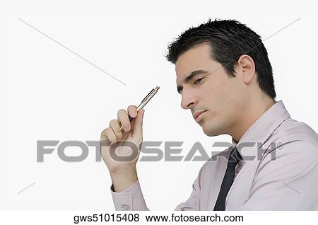Side profile of a businessman holding a pen and thinking View Large Photo Image Stock Photo - Side profile of a businessman holding a pen and thinking. Fotosearch