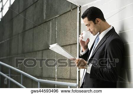 Side profile of a businessman reading a newspaper View Large Photo Image Stock Photograph - Side profile of a businessman reading a newspaper. Fotosearch