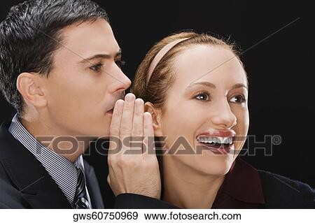 Side profile of a businessman whispering to a businesswoman View Large Photo Image Stock Photo - Side profile of a businessman whispering to a businesswoman. Fotosearch