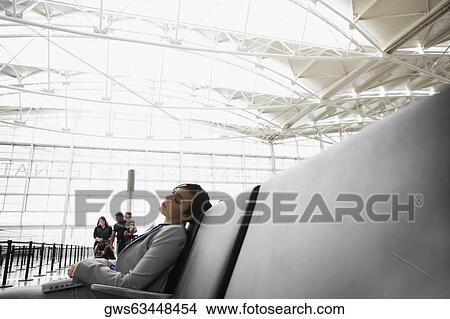 Picture - Side profile of a businesswoman sleeping at an airport. Fotosearch