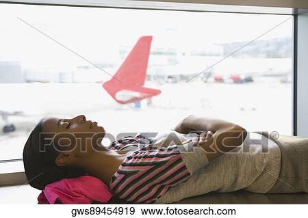 Stock Photo - Side profile of a businesswoman sleeping at an airport. Fotosearch