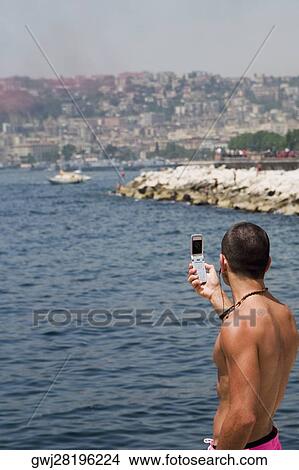 Side profile of a man photographing with a mobile phone, Bay of Naples, Naples, Naples Province, Campania, Italy View Large Photo Image Picture - Side profile of a man photographing with a mobile phone, Bay of Naples, Naples, Naples Province, Campania, Italy. Fotosearch