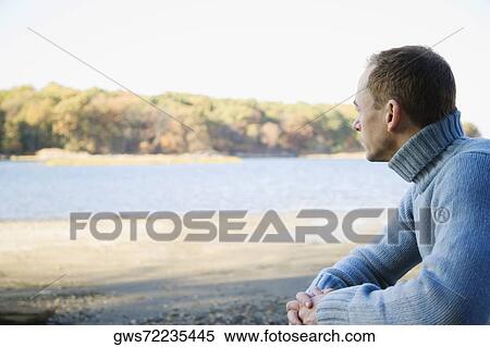 Side profile of a mid adult man sitting with his hands clasped View Large Photo Image Stock Photography - Side profile of a mid adult man sitting with his hands clasped. Fotosearch