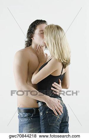 Side profile of a young couple kissing each other View Large Photo Image Stock Photo - Side profile of a young couple kissing each other. Fotosearch