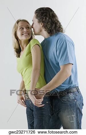 Side profile of a young couple romancing View Large Photo Image Stock Photograph - Side profile of a young couple romancing. Fotosearch