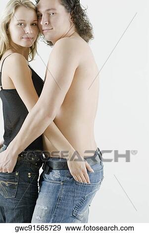 Stock Photo - Side profile of a young couple embracing each other. Fotosearch