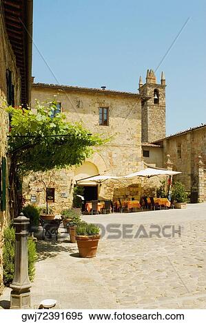 Stock Photography - Sidewalk cafe beside a church, Romanesque Church, Piazza Roma, Monteriggioni, Siena Province, Tuscany, Italy. Fotosearch