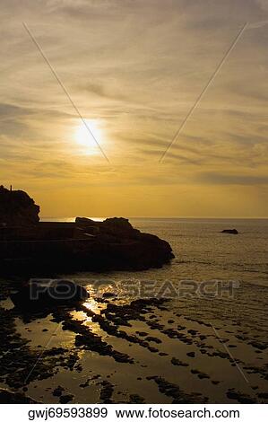 Silhouette of rocks in the sea at dusk, Biarritz, Basque Country, Pyrenees-Atlantiques, Aquitaine, France View Large Photo Image Stock Photo - Silhouette of rocks in the sea at dusk, Biarritz, Basque Country, Pyrenees-Atlantiques, Aquitaine, France. Fotosearch