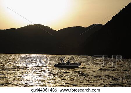 Silhouette of two people in an inflatable raft, Italian Riviera, Mar Ligure, Genoa, Liguria, Italy View Large Photo Image Stock Photography - Silhouette of two people in an inflatable raft, Italian Riviera, Mar Ligure, Genoa, Liguria, Italy. Fotosearch
