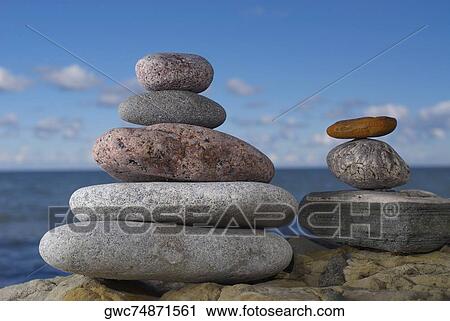 Stock Image - Stacks of pebbles on a rock. Fotosearch