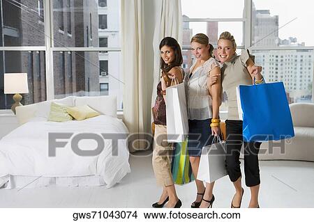 Three young women holding shopping bags View Large Photo Image Picture - Three young women holding shopping bags. Fotosearch