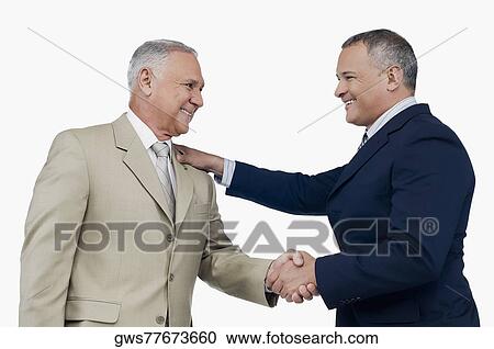 Two businessmen shaking hands and smiling View Large Photo Image Stock Image - Two businessmen shaking hands and smiling. Fotosearch