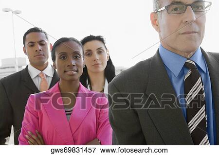Two businessmen standing at an airport with two businesswomen View Large Photo Image Stock Photo - Two businessmen standing at an airport with two businesswomen. Fotosearch