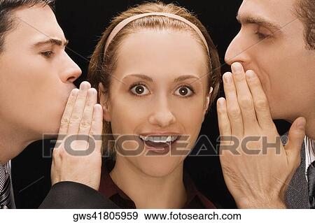 Two businessmen whispering to a businesswoman View Large Photo Image Stock Photo - Two businessmen whispering to a businesswoman. Fotosearch