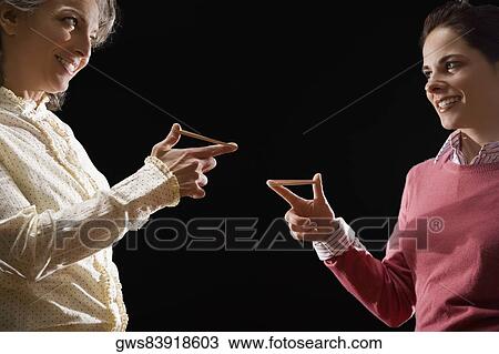 Two businesswomen playing with rubber band and smiling View Large Photo Image Stock Image - Two businesswomen playing with rubber band and smiling. Fotosearch