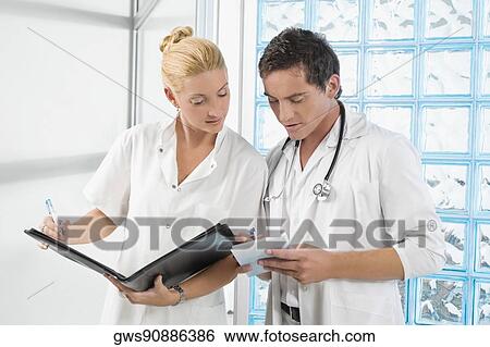 Stock Photograph - Two doctors discussing a medical report. Fotosearch