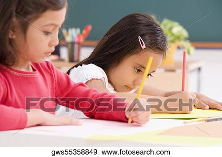 Two girls drawing in a classroom View Large Photo Image Stock Photo - Two girls drawing in a classroom. Fotosearch