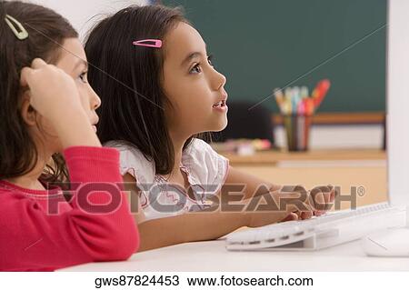 Two girls in front of a desktop PC in a classroom View Large Photo Image Stock Image - Two girls in front of a desktop PC in a classroom. Fotosearch