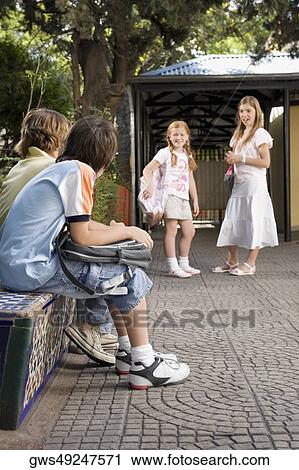 Two schoolboys looking at two schoolgirls View Large Photo Image Stock Image - Two schoolboys looking at two schoolgirls. Fotosearch