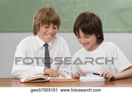 Two schoolboys studying in a classroom View Large Photo Image Stock Image - Two schoolboys studying in a classroom. Fotosearch