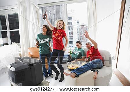 Two young couples enjoying beer and dancing in a living room View Large Photo Image Stock Image - Two young couples enjoying beer and dancing in a living room. Fotosearch