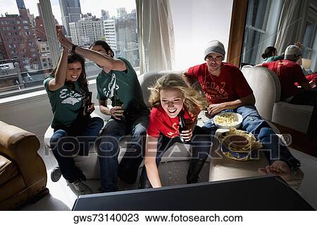 Two young couples watching television and drinking beer in a living room View Large Photo Image Stock Image - Two young couples watching television and drinking beer in a living room. Fotosearch