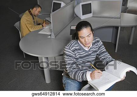 Two young men sitting in a computer lab and writing View Large Photo Image Picture - Two young men sitting in a computer lab and writing. Fotosearch