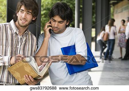 Two young men standing in a corridor View Large Photo Image Stock Photo - Two young men standing in a corridor. Fotosearch
