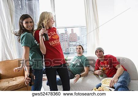 Two young women dancing with two young men looking at them View Large Photo Image Stock Image - Two young women dancing with two young men looking at them. Fotosearch