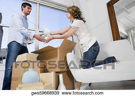 Young couple unpacking cardboard boxes View Large Photo Image Stock Photo - Young couple unpacking cardboard boxes. Fotosearch