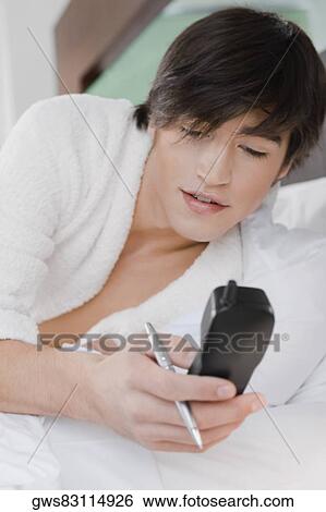 Young man holding a cordless phone View Large Photo Image Stock Photograph - Young man holding a cordless phone. Fotosearch