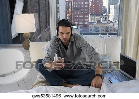 Young man listening to an MP3 player View Large Photo Image Stock Photograph - Young man listening to an MP3 player. Fotosearch