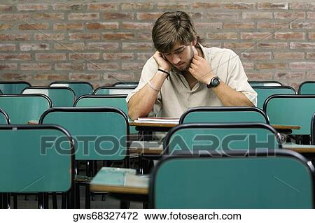 Young man sitting in a classroom View Large Photo Image Stock Image - Young man sitting in a classroom. Fotosearch