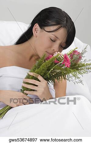 Young woman smelling a bouquet of flowers View Large Photo Image Stock Photo - Young woman smelling a bouquet of flowers. Fotosearch