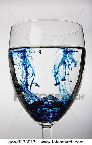 Blue substance dissolving in a glass of water View Large Photo Image Stock Image - Blue substance dissolving in a glass of water. Fotosearch